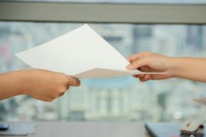 person handing over paper